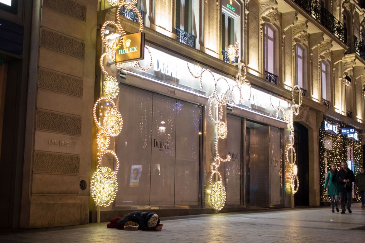 Obdachloser unter Rolex Schild in Paris