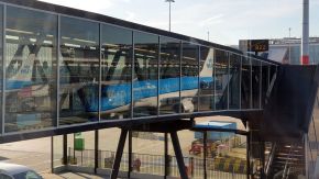 KLM Flugzeug als Reflektion im Glas einer Passagierbrücke am Flughafen Amsterdam Schiphol