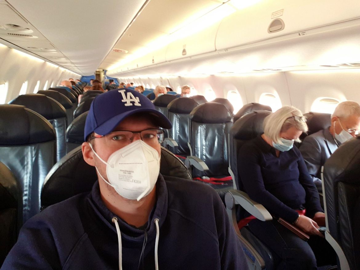 Robert mit Atemschutzmaske in KLM Flugzeug