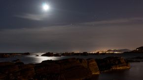 Nachts am Strand von St. Raphael mit der Küste im Hintergrund bei Mondschein