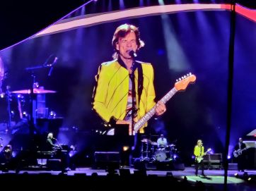 Mick Jagger in gelber Jacke beim Rolling Stones Konzert 2022