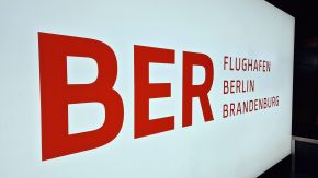 Schild mit Logo des Flughafens BER