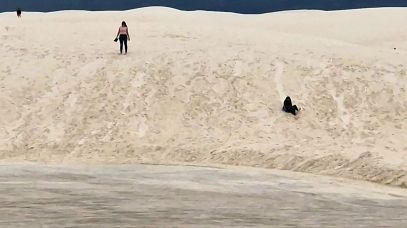 Leute rodeln Dünen herunter im White Sands Nationalpark, New Mexico