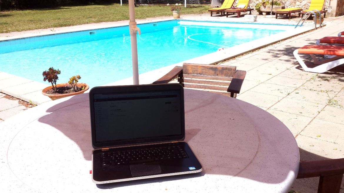 Arbeiten mit Laptop am Pool