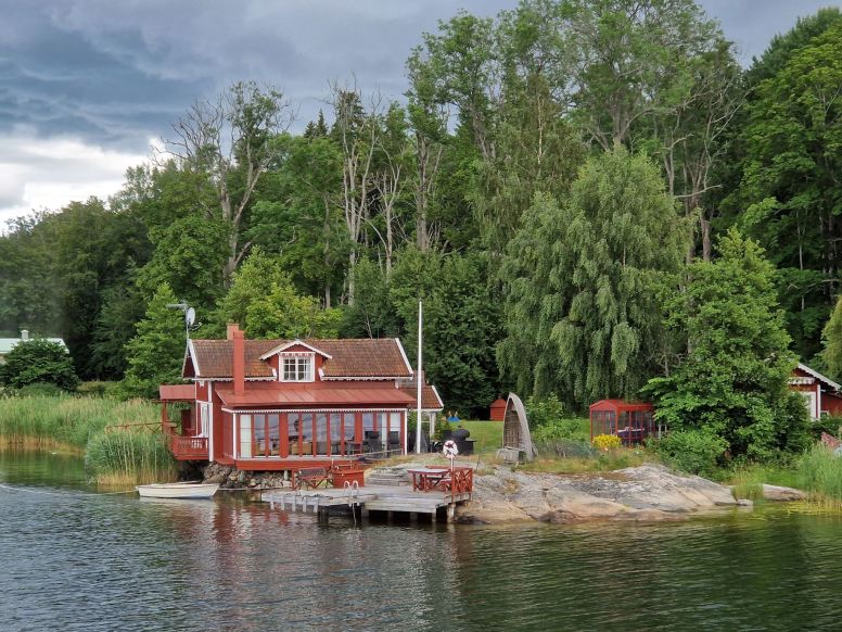 Rote Holzhäuser auf Schäre vor Stockholm, Schweden