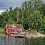 Rote Holzhäuser auf Schäre vor Stockholm, Schweden