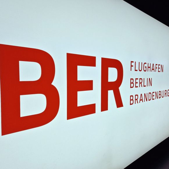Schild mit Logo des Flughafens BER
