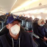 Robert mit Atemschutzmaske in KLM Flugzeug